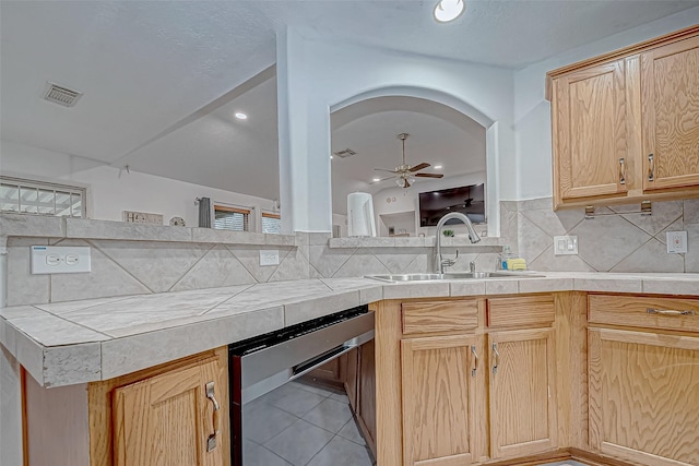 kitchen with tile countertops, decorative backsplash, ceiling fan, and sink