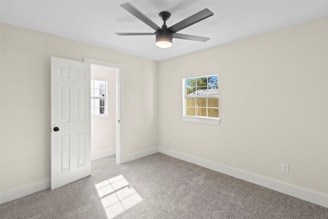 empty room with ceiling fan and light carpet