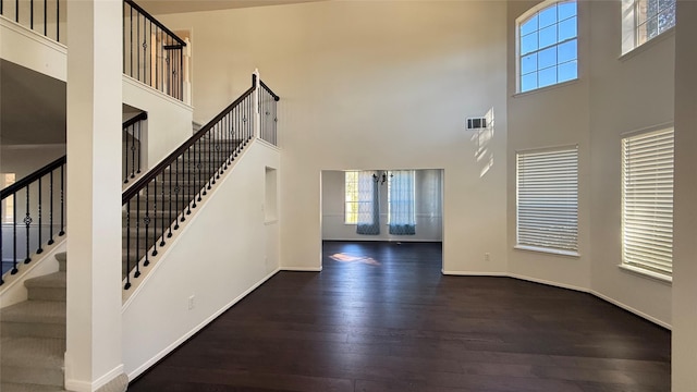 entrance foyer with french doors, a towering ceiling, and dark hardwood / wood-style floors