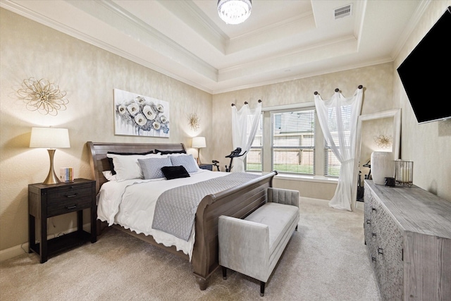 carpeted bedroom with a tray ceiling and ornamental molding