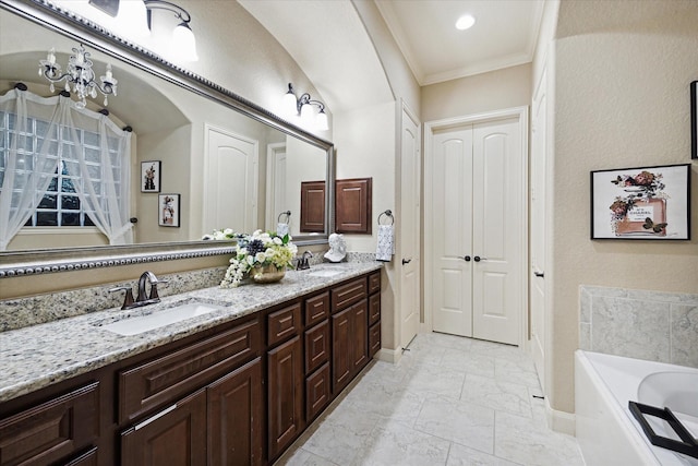 bathroom featuring a chandelier, vanity, a tub to relax in, and crown molding