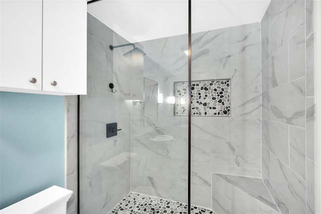 bathroom featuring toilet and a tile shower