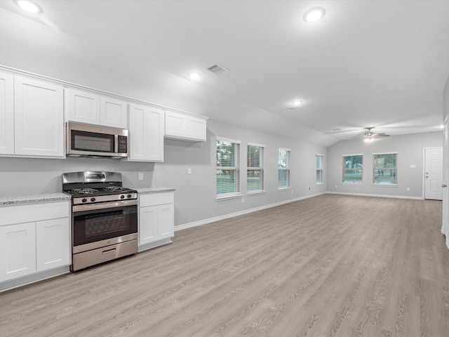 kitchen featuring stainless steel appliances, ceiling fan, light hardwood / wood-style floors, white cabinetry, and lofted ceiling