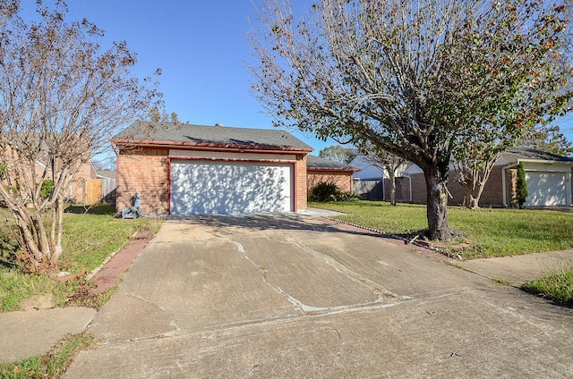 view of front of property with a garage, an outdoor structure, and a front yard