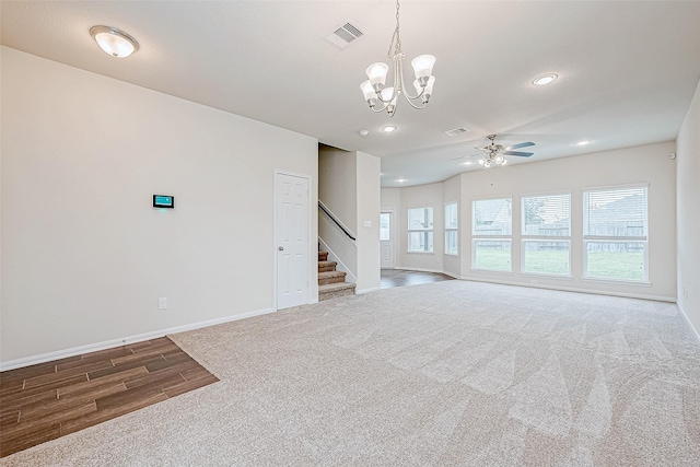 unfurnished living room with carpet flooring and ceiling fan with notable chandelier