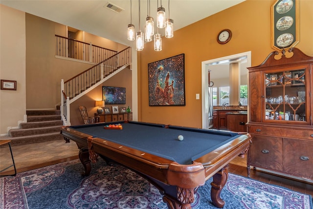 playroom featuring dark hardwood / wood-style flooring, a towering ceiling, and billiards