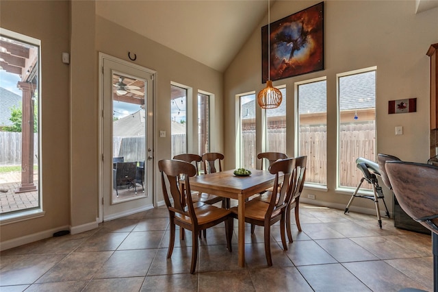 tiled dining room featuring a healthy amount of sunlight and lofted ceiling