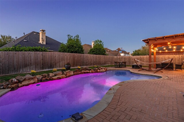 pool at dusk with a patio