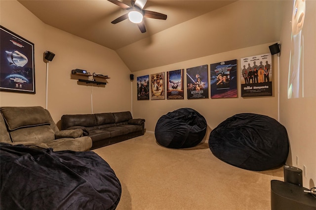 carpeted home theater room with ceiling fan and vaulted ceiling