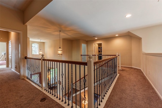 corridor with carpet and an inviting chandelier