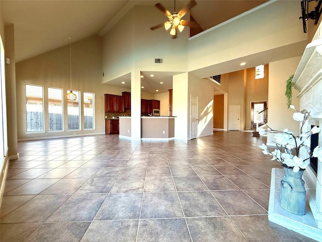 unfurnished living room with tile patterned flooring, ceiling fan, and high vaulted ceiling