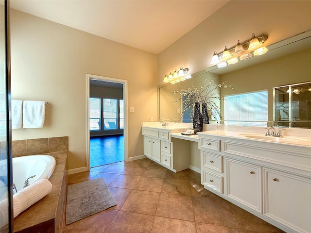 bathroom featuring vanity, tile patterned floors, and tiled tub