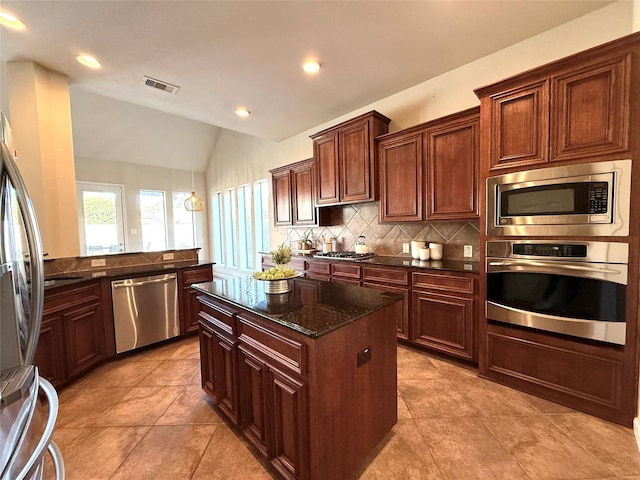 kitchen with stainless steel appliances, backsplash, dark stone counters, vaulted ceiling, and light tile patterned floors