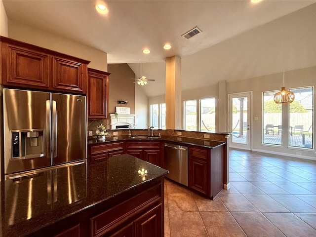 kitchen with ceiling fan, kitchen peninsula, sink, and appliances with stainless steel finishes