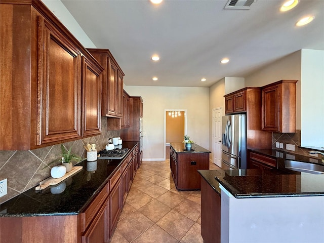 kitchen featuring stainless steel appliances, a kitchen island, tasteful backsplash, and sink