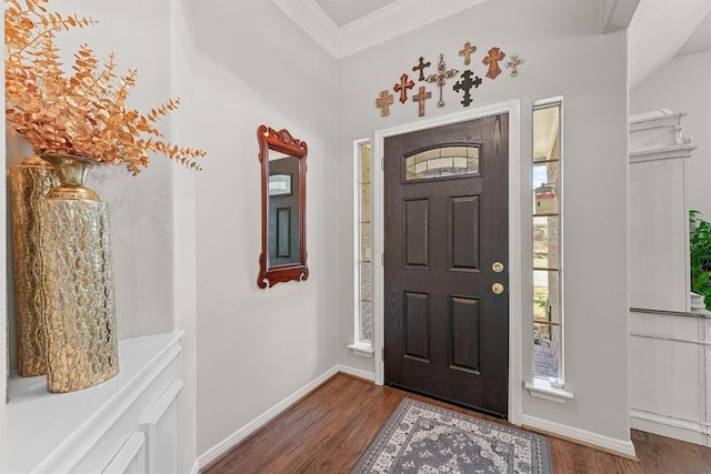 foyer featuring baseboards, ornamental molding, and wood finished floors