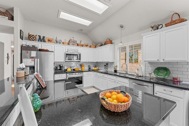 kitchen featuring appliances with stainless steel finishes, white cabinets, and a sink