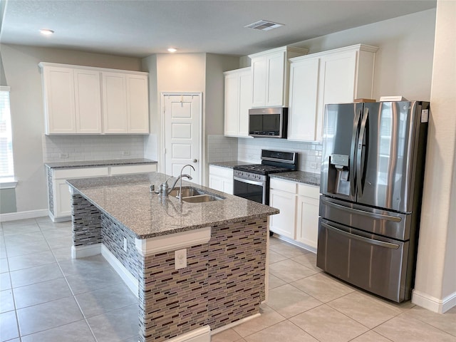 kitchen with sink, stainless steel appliances, white cabinets, stone countertops, and light tile patterned flooring