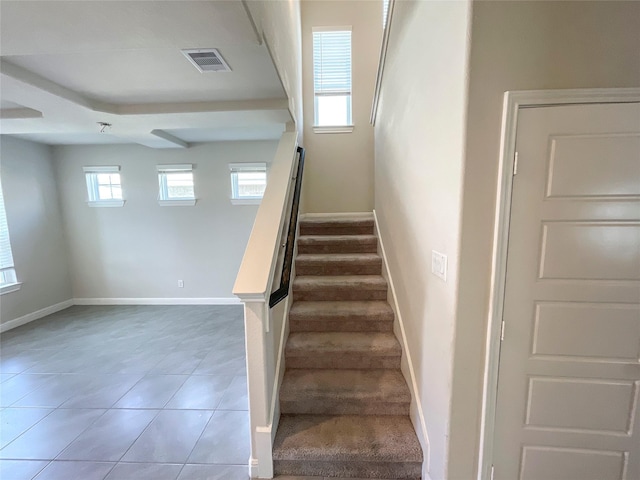 staircase with tile patterned floors and a healthy amount of sunlight