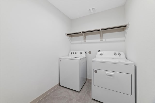 clothes washing area with light tile patterned flooring and independent washer and dryer