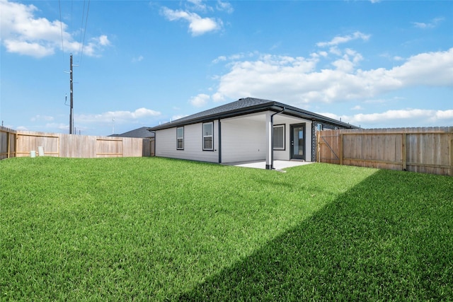 rear view of house featuring a patio area and a yard