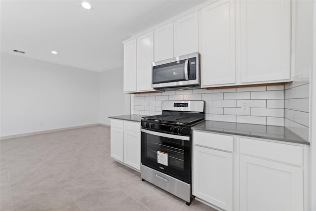 kitchen featuring backsplash, white cabinets, light tile patterned floors, and appliances with stainless steel finishes