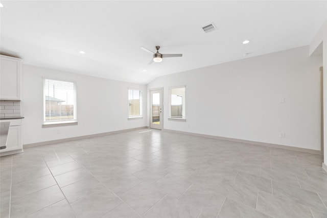 unfurnished living room with ceiling fan, light tile patterned flooring, and vaulted ceiling