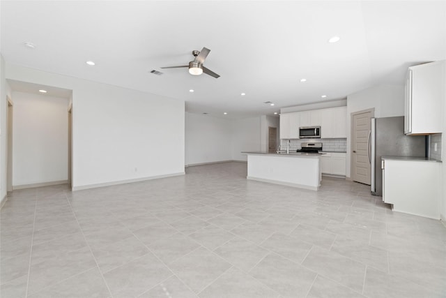 unfurnished living room with ceiling fan, light tile patterned floors, and sink