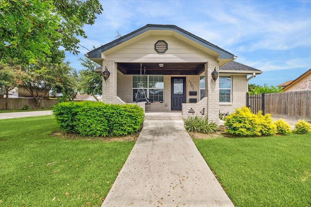 bungalow-style house with covered porch and a front lawn