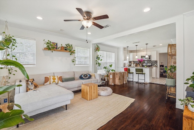 living room with wood-type flooring, ceiling fan, and crown molding