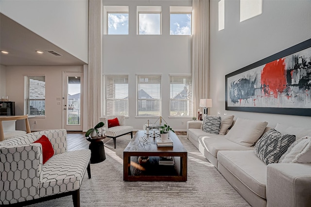 living room with hardwood / wood-style flooring and a towering ceiling