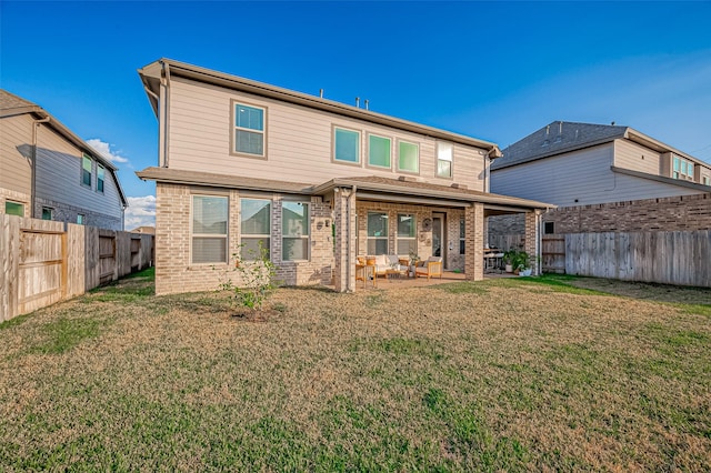 rear view of property with a lawn and a patio