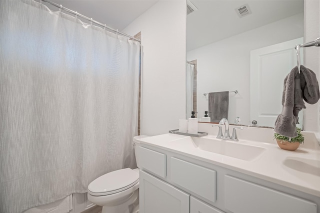 bathroom with vanity, a shower with shower curtain, and toilet