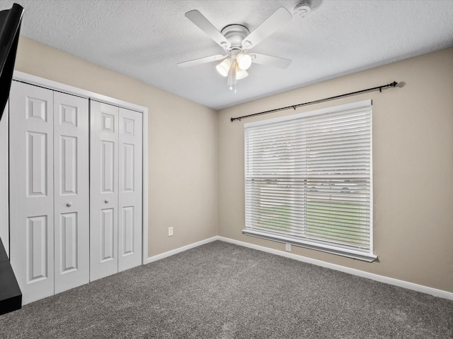 unfurnished bedroom with carpet flooring, ceiling fan, a closet, and multiple windows