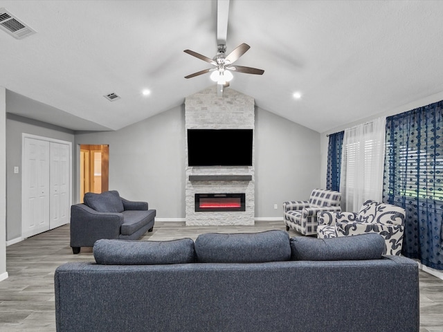 living room with a fireplace, hardwood / wood-style floors, ceiling fan, and lofted ceiling