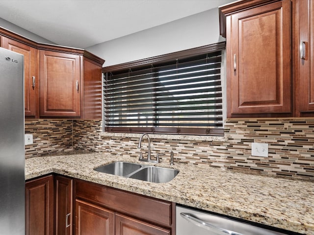 kitchen with tasteful backsplash, light stone countertops, sink, and stainless steel appliances