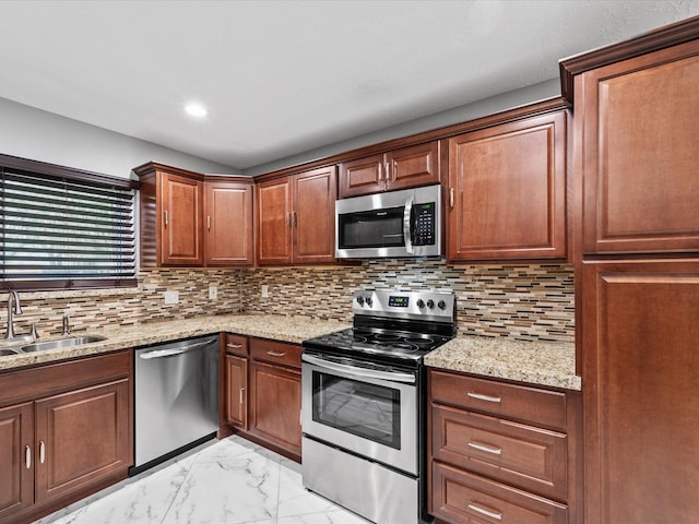 kitchen featuring decorative backsplash, light stone counters, sink, and appliances with stainless steel finishes