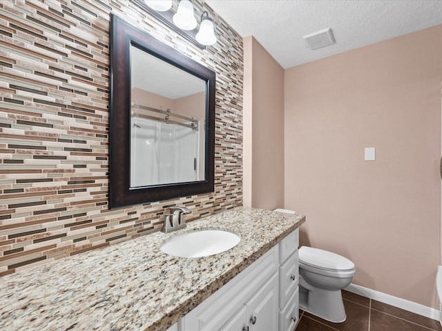 bathroom with walk in shower, tasteful backsplash, tile patterned flooring, a textured ceiling, and vanity