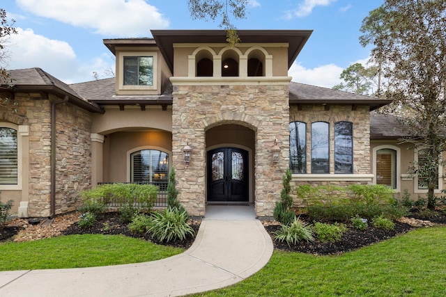 property entrance featuring a lawn and french doors