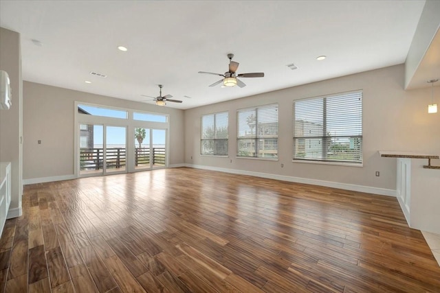 unfurnished living room featuring hardwood / wood-style floors and ceiling fan