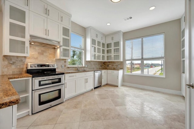 kitchen featuring backsplash, stainless steel appliances, sink, stone counters, and white cabinetry