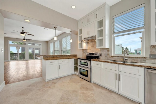 kitchen with hanging light fixtures, white cabinetry, sink, and stainless steel appliances