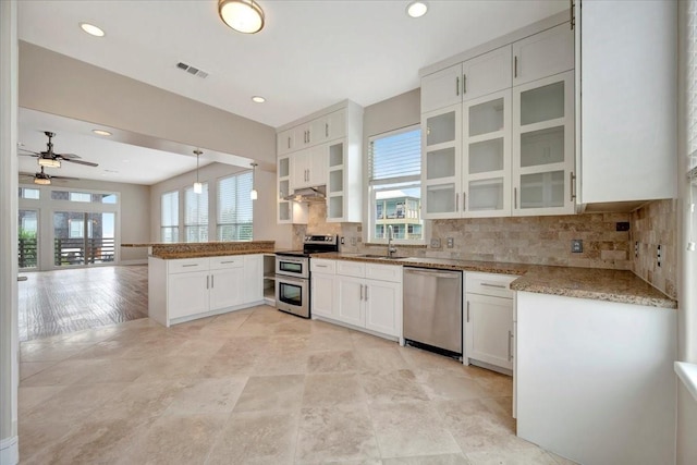 kitchen with white cabinetry, stainless steel appliances, backsplash, kitchen peninsula, and decorative light fixtures