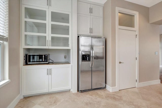 kitchen with white cabinets, stainless steel appliances, and light stone countertops