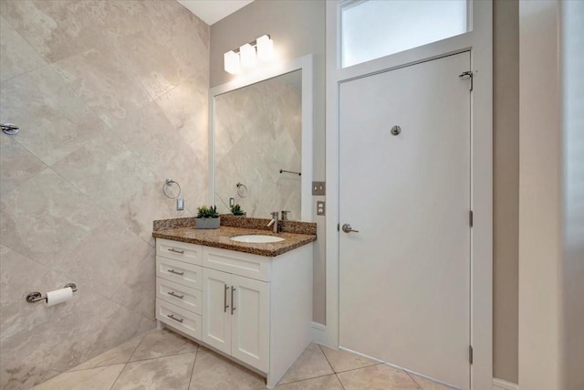 bathroom featuring tile patterned flooring, vanity, and tile walls