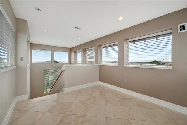 tiled empty room featuring a healthy amount of sunlight