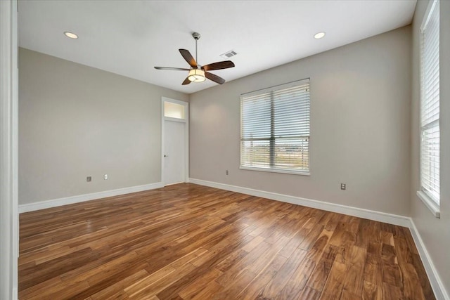 empty room with hardwood / wood-style flooring, plenty of natural light, and ceiling fan