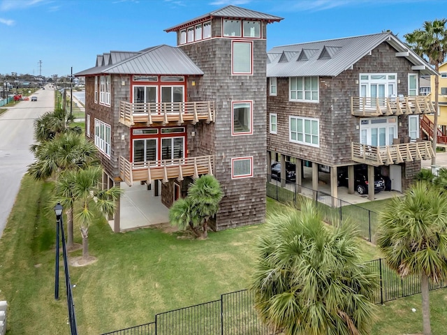 rear view of property featuring a yard and a balcony