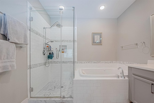 bathroom featuring vanity and independent shower and bath