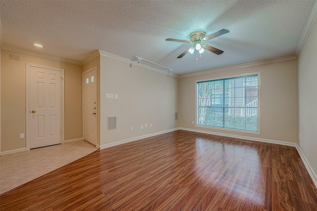 empty room featuring a textured ceiling, ceiling fan, light wood-type flooring, and crown molding